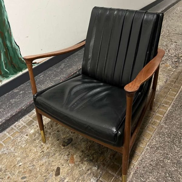 Silla de cuero negro con estructura de madera